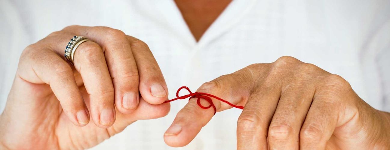 A red string tied around a finger as a reminder